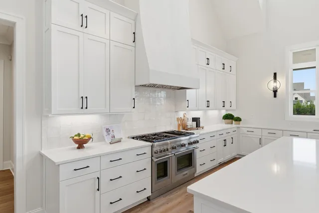 a kitchen with granite countertop white cabinets and white appliances