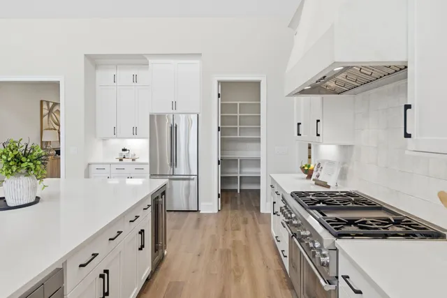 a kitchen with stainless steel appliances a stove a sink and cabinets