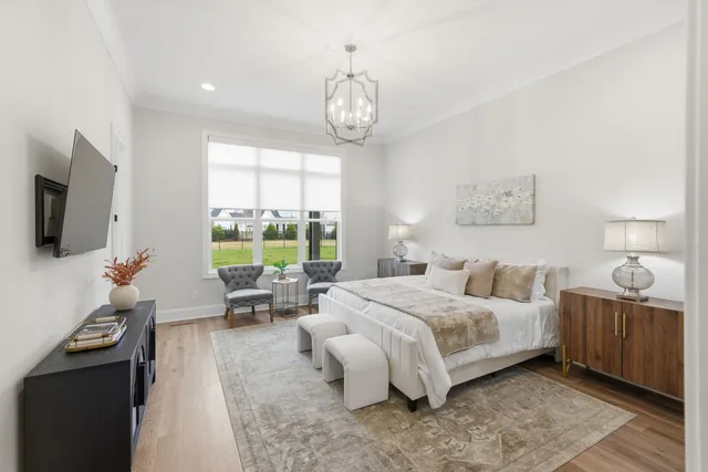 a bedroom with bed and a flat tv screen on dresser