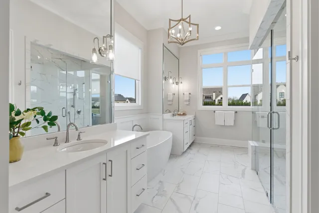 a spacious bathroom with a double vanity sink a mirror a bathtub and a shower