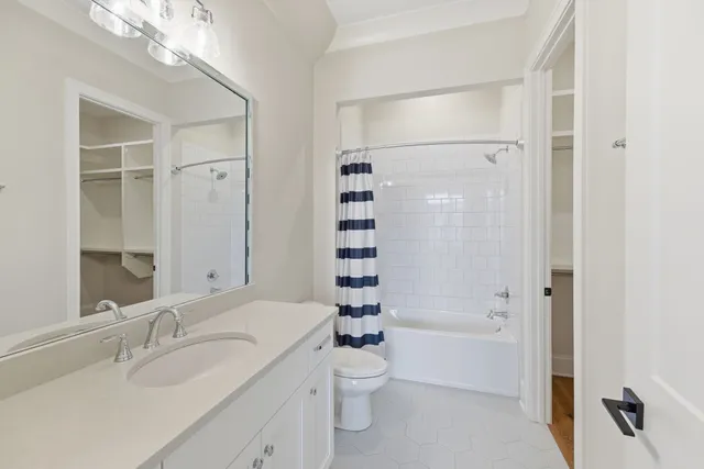 a bathroom with a bathtub shower sink mirror and toilet