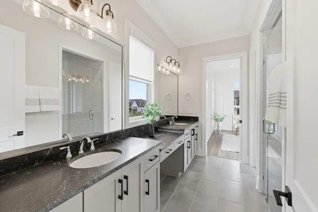 a bathroom with a granite countertop double vanity sink and a mirror
