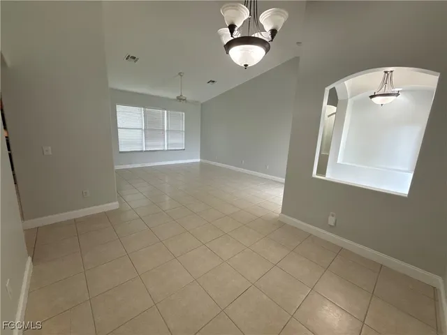 en empty room with windows and fan