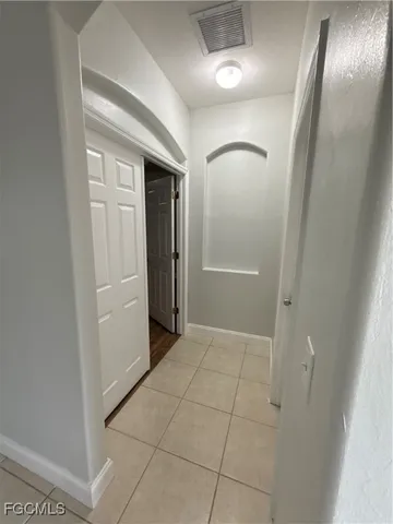 an empty room with mirror and entrance