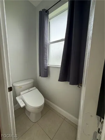 a white toilet sitting next to a window