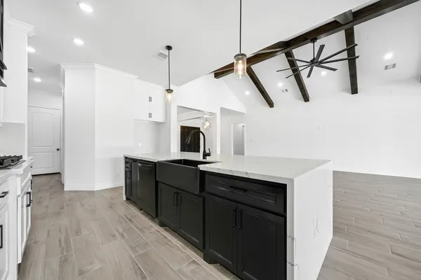 a kitchen with stainless steel appliances a sink a stove a refrigerator and cabinets