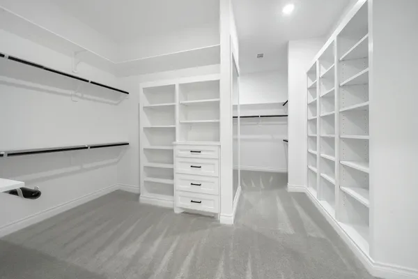 a view of walk in closet with empty racks