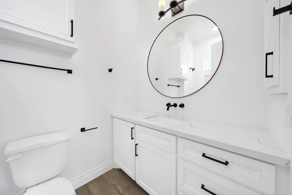 a bathroom with a sink a toilet and a mirror