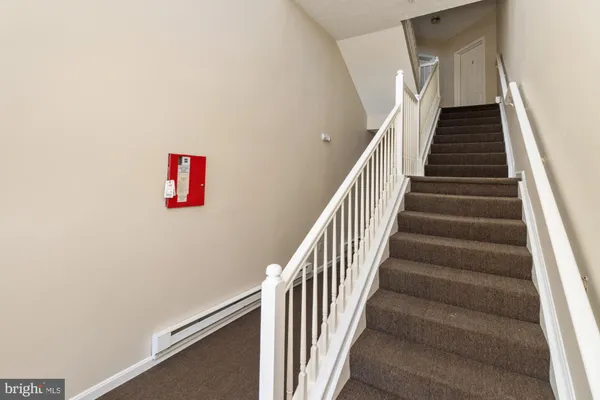 a view of staircase with wooden floor and white walls