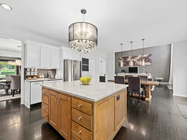a kitchen that has a lot of cabinets stainless steel appliances and wooden floor