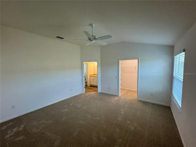 an empty room with a window and a fan
