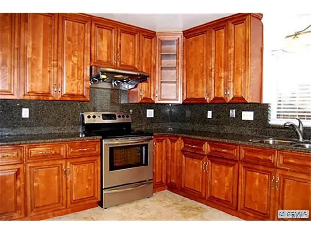 a kitchen with stainless steel appliances granite countertop a sink a stove and a microwave