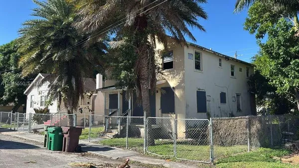 a front view of a house with tree