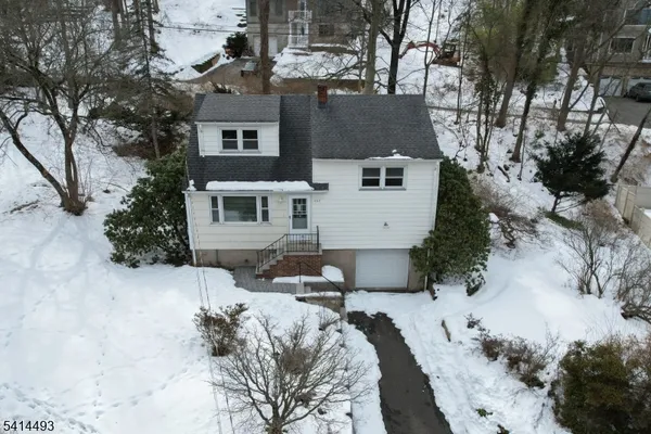 a view of a house with a yard covered in snow