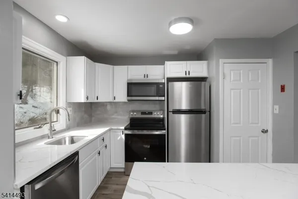 a kitchen with a refrigerator sink and cabinets