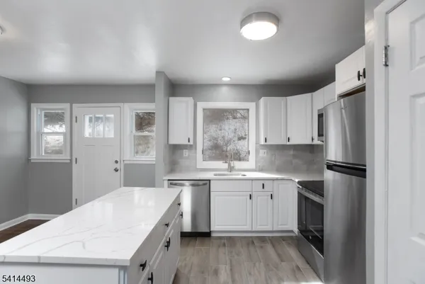 a kitchen with a sink a refrigerator and cabinets