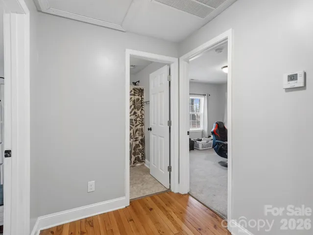 a bedroom with a bed a dresser and painting on the wall
