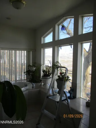 a view of a dining room and livingroom with furniture wooden floor a chandelier