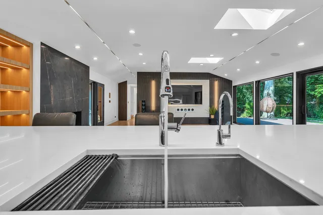 a kitchen with stainless steel appliances kitchen island granite countertop a refrigerator and a sink