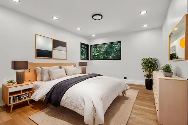 a bedroom with a large bed and a potted plant