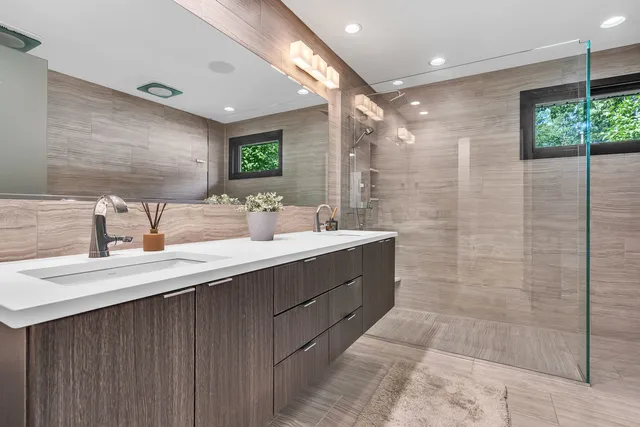 a bathroom with a double vanity sink mirror and shower