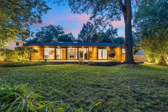 a view of a house with backyard and sitting area