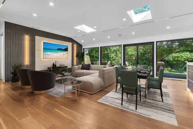 a living room with furniture a floor to ceiling window and a flat screen tv