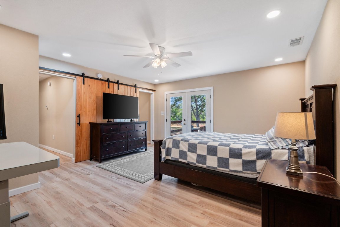 215 Go Away Road Blanco, TX 78606 - Photo 18 of 29 a bedroom with a bed and a flat screen tv