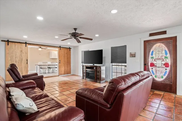 a living room with furniture a large window and a flat screen tv