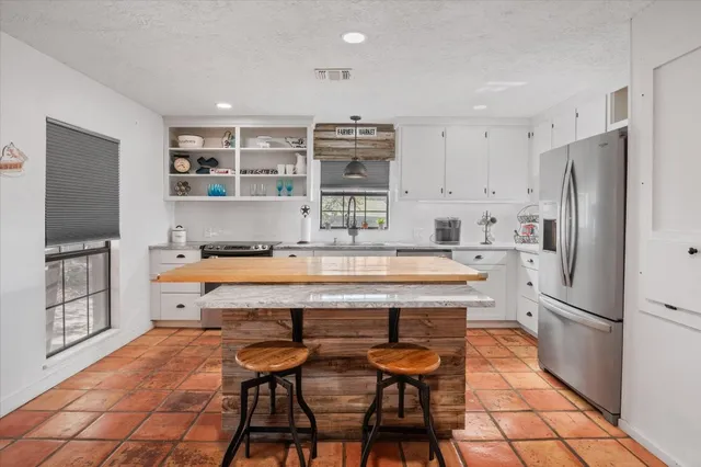 a kitchen with stainless steel appliances a refrigerator and a stove top oven