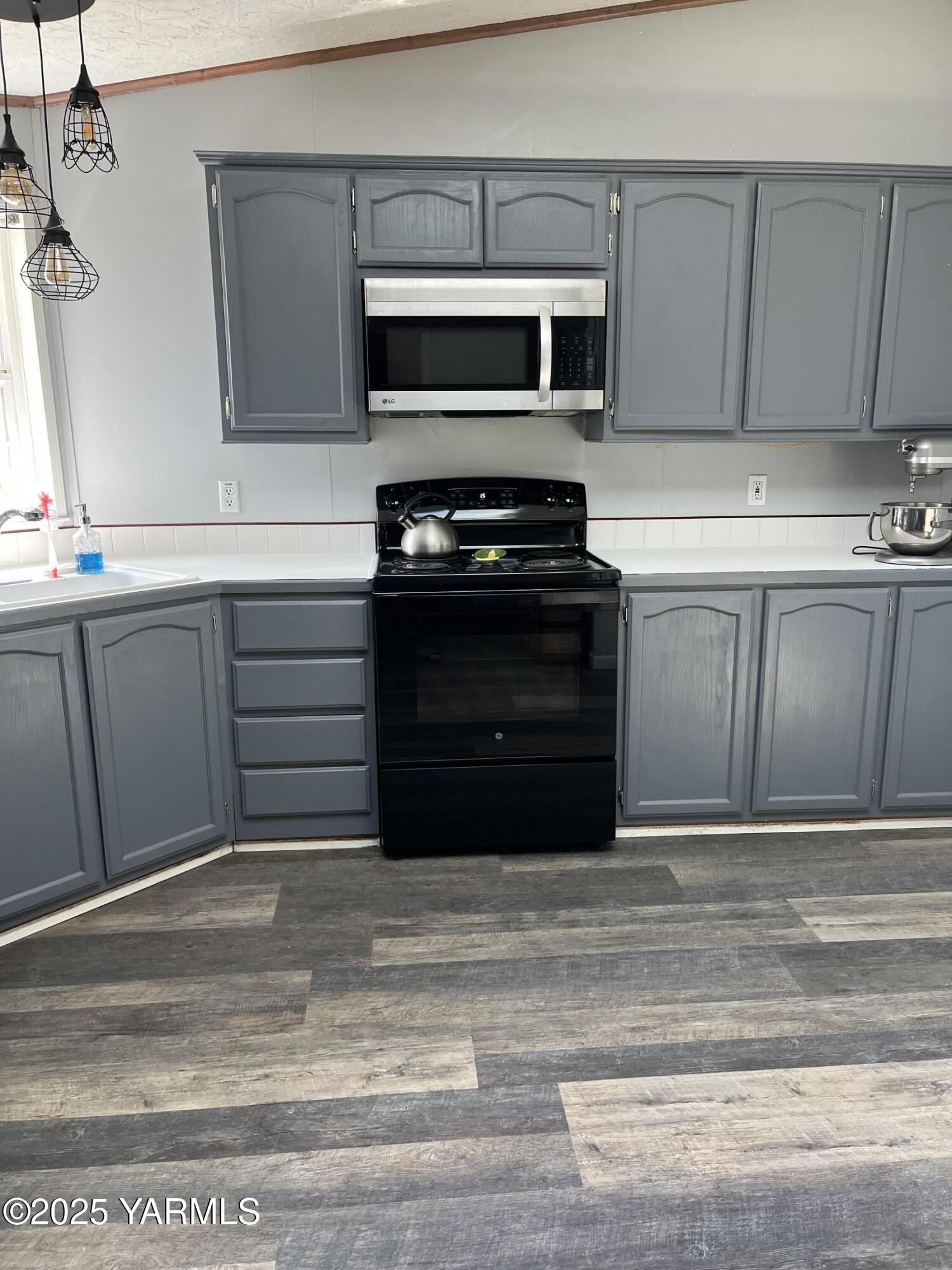 14190 North Wenas Road Selah, WA 98942 - Photo 12 of 62 a kitchen with granite countertop a stove and a microwave