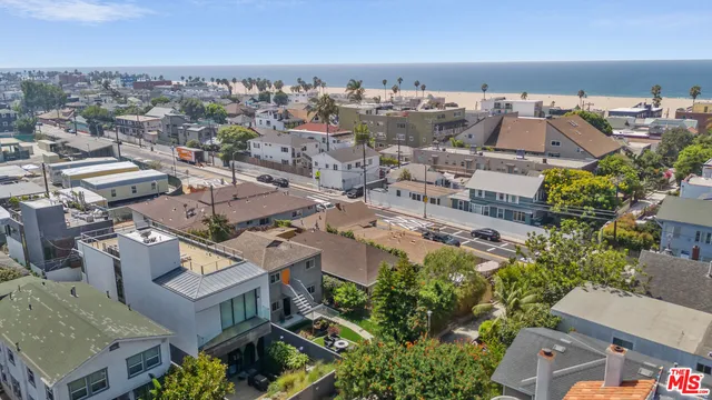 an aerial view of a house with a yard and mountain view in back