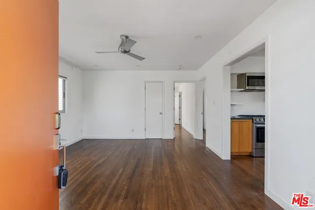 a view of a room with wooden floor and a ceiling fan