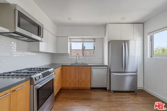 a kitchen with granite countertop a refrigerator stove and microwave