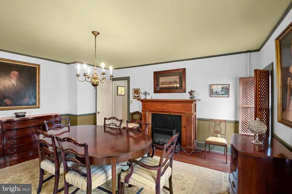 a dining room with furniture a chandelier and wooden floor