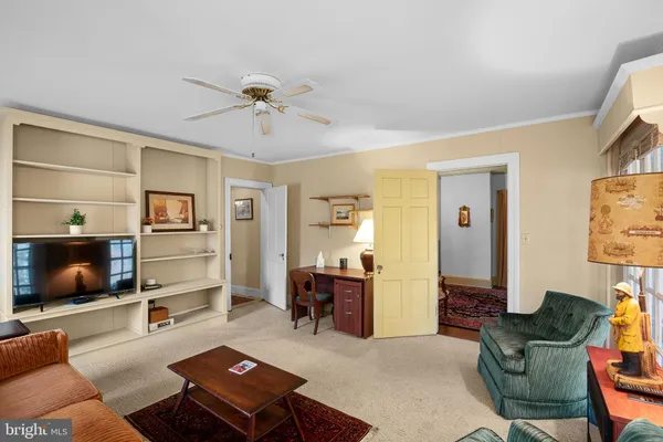 a living room with furniture ceiling fan and a window