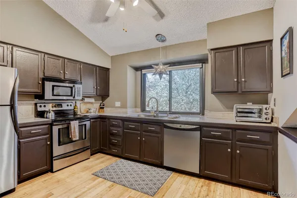 a kitchen with stainless steel appliances granite countertop a stove sink and cabinets