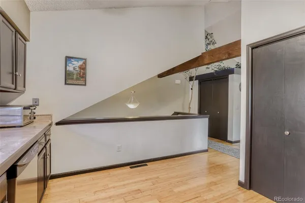 a living room with stainless steel appliances with wooden floor