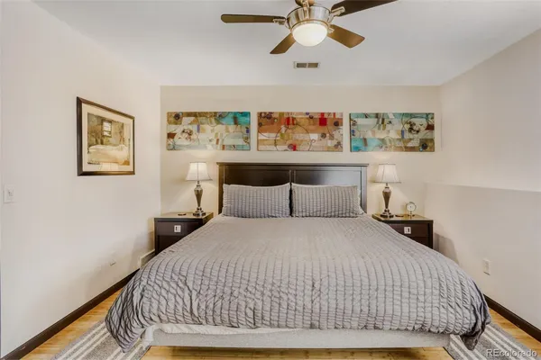 a bedroom with a bed and painting on the wall