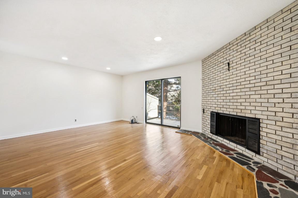 635 East Main Street, Unit 14 Moorestown, NJ 08057 - Photo 9 of 32 an empty room with wooden floor fireplace and windows