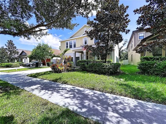 a kitchen with stainless steel appliances granite countertop wooden cabinets a refrigerator a sink a stove a dining table and chairs