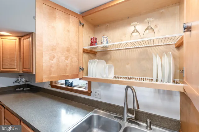 a large kitchen with kitchen island a large window cabinets and stainless steel appliances