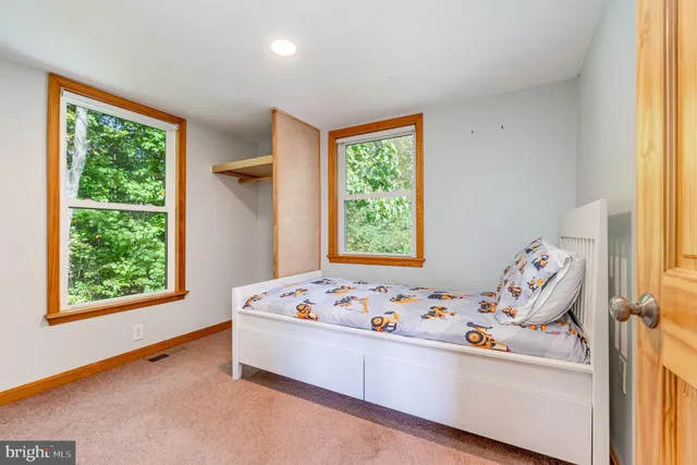 a white bed sitting in a bedroom next to a window