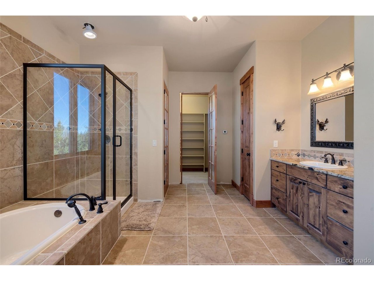 5200 Jackson Road Walden, CO 80480 - Photo 18 of 40 Primary bath with large soaking tub, walk-in shower, private toiletries, sink, linen closet, and walk-in closet