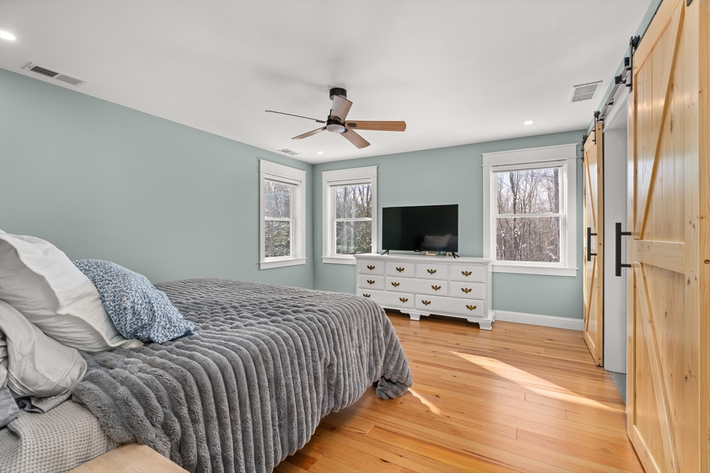 654 Skyline Trail Chester, MA 01011 - Photo 16 of 32 a bedroom with a bed and a flat screen tv