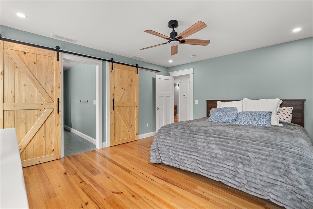 654 Skyline Trail Chester, MA 01011 - Photo 17 of 32 a bedroom with a large bed and a chandelier