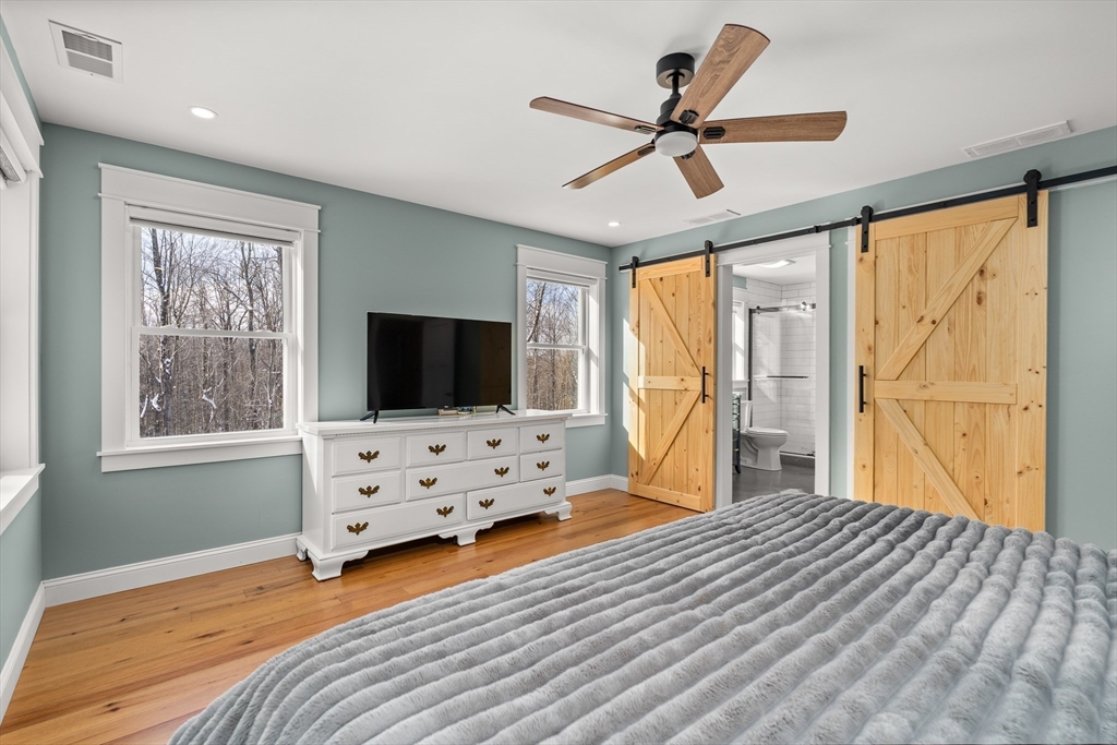 654 Skyline Trail Chester, MA 01011 - Photo 18 of 32 a bedroom with a bed and a flat screen tv