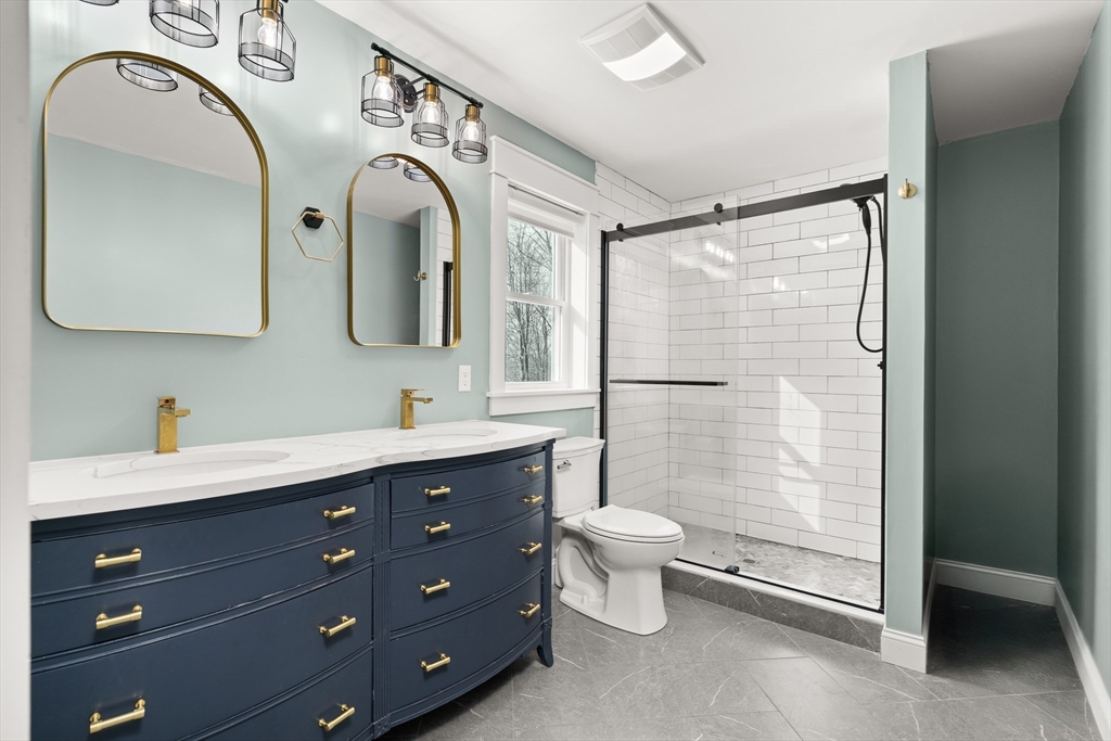 654 Skyline Trail Chester, MA 01011 - Photo 19 of 32 a spacious bathroom with a double vanity sink toilet mirror and shower