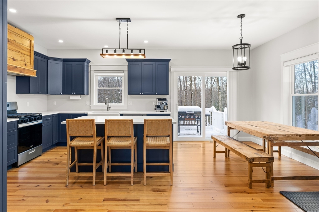 654 Skyline Trail Chester, MA 01011 - Photo 7 of 32 a dining room with wooden floor a chandelier a wooden table and chairs