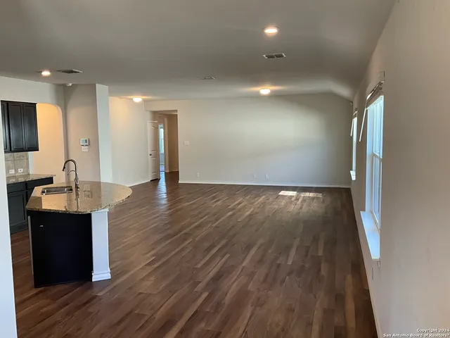 a view of a kitchen with wooden floor and staircase
